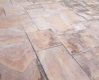 Indian sandstone cleaning in Heanor, This rainbow sandstone patio had been cleaned by the home owner but he could not remove the black staining, check out the next picture to see what a professional clean looks like!: Click Here To View Larger Image